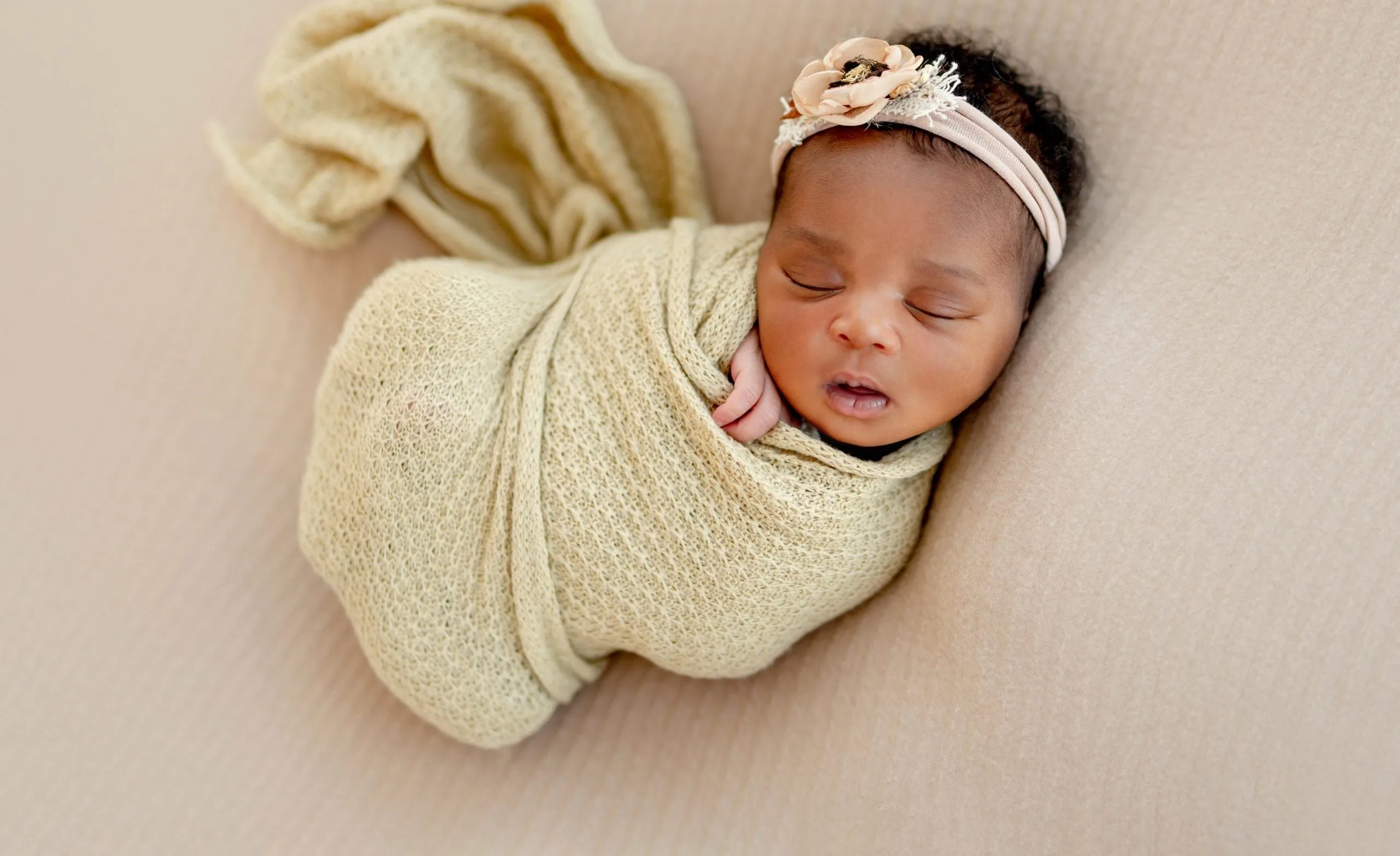 sleeping new born baby wrapped in a blanket